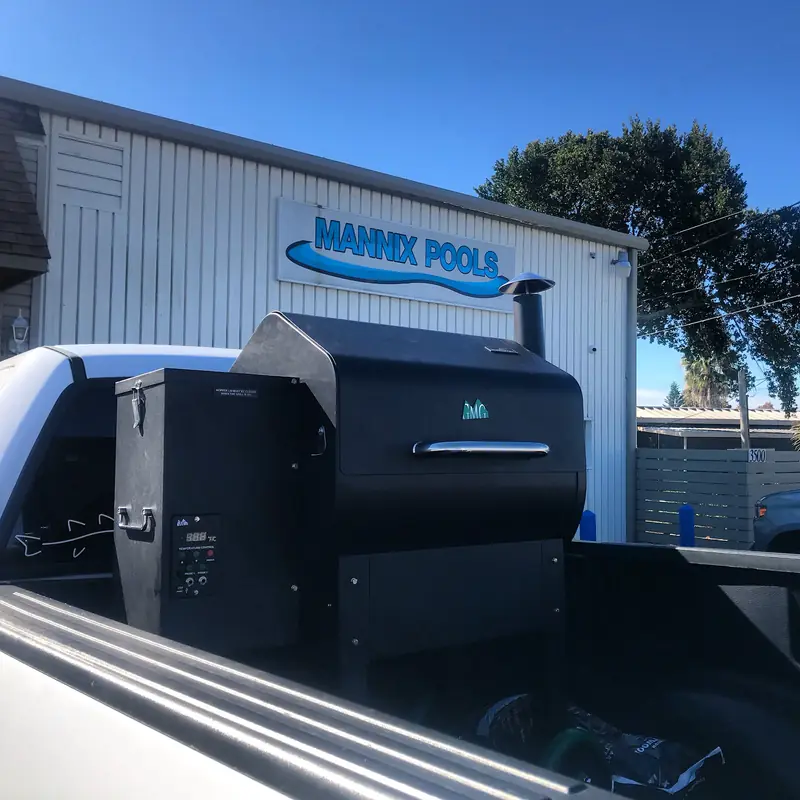 The Mannix Pools building and sign on Cypress Gardens Road, a pellet grill in a truck bed out front